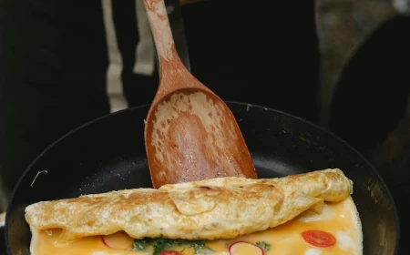 person cooking an omlet with veggies