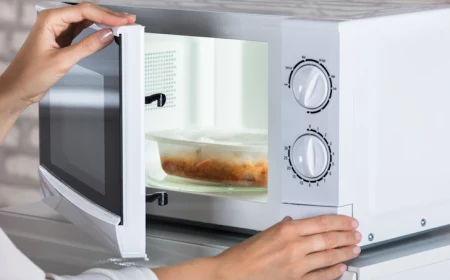 person heating up leftovers in microwave