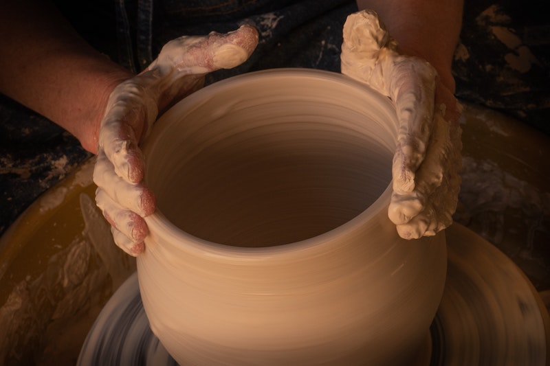 person molding clay with their hands