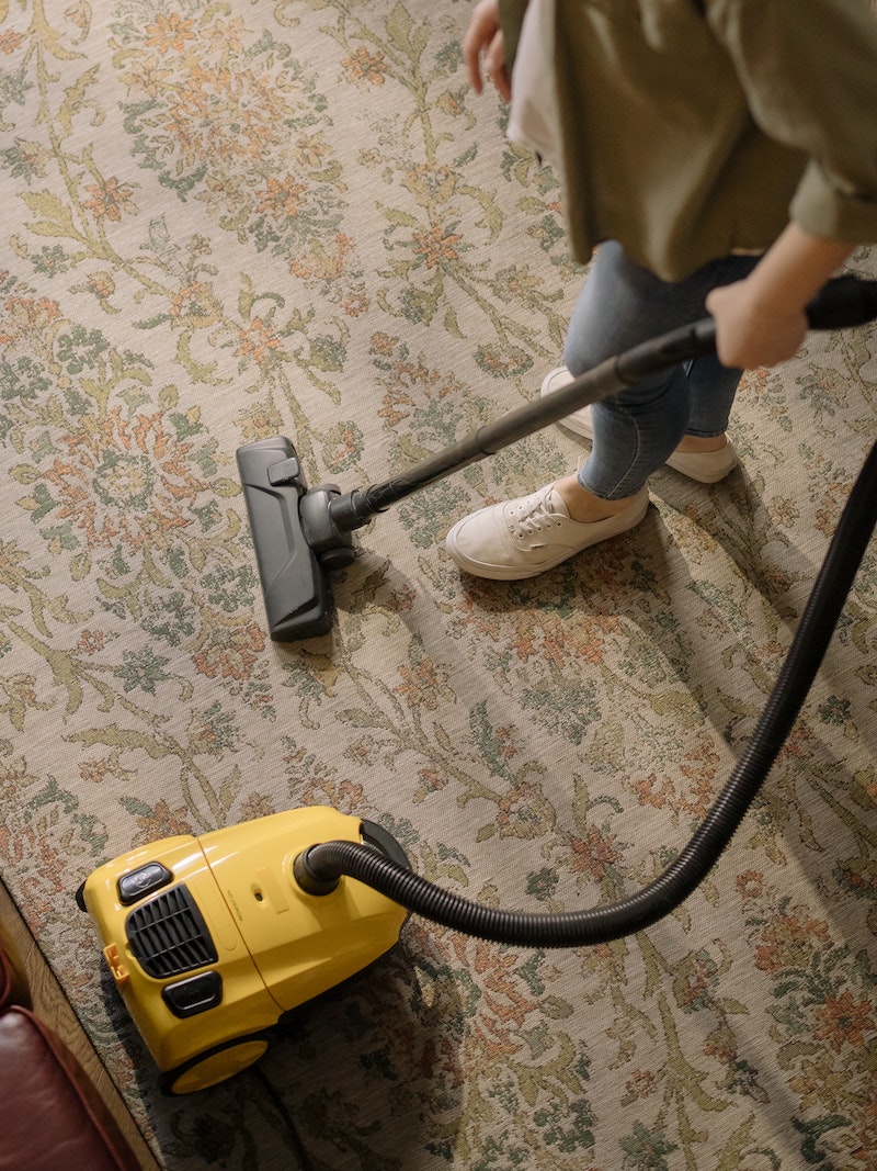 places to clean in your home person vaccuming a rug
