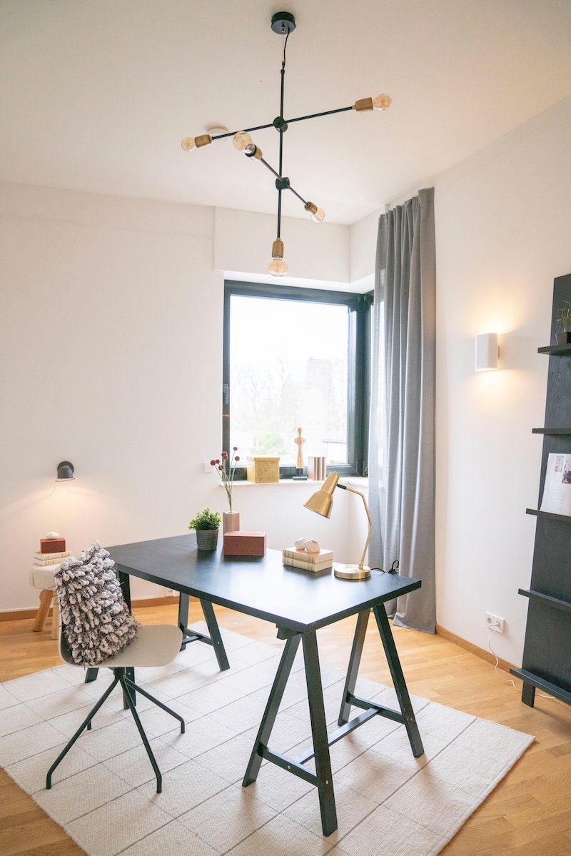 tall white room with desk and chair