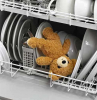 teddy bear lying in the dishwasher