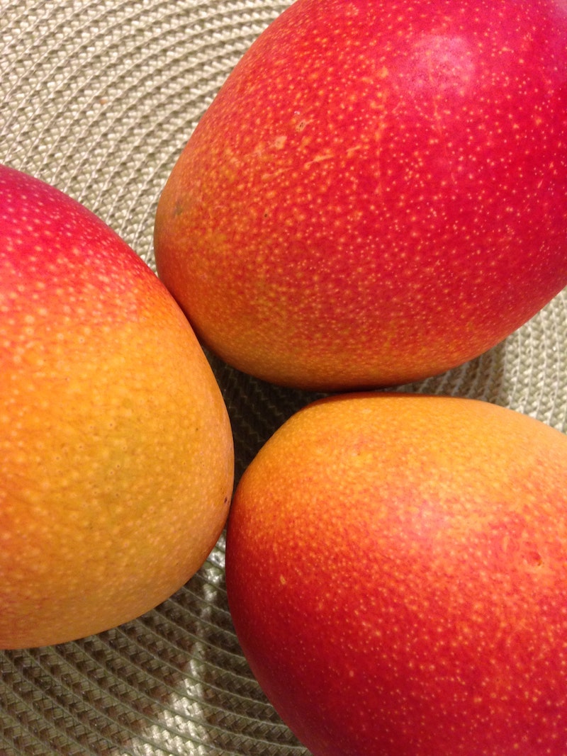 three orange and pink mangoes