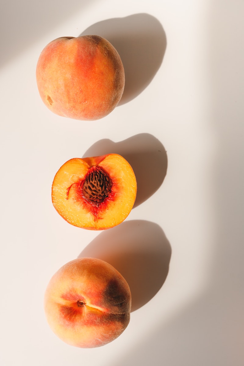 two peaches and half a cut peach