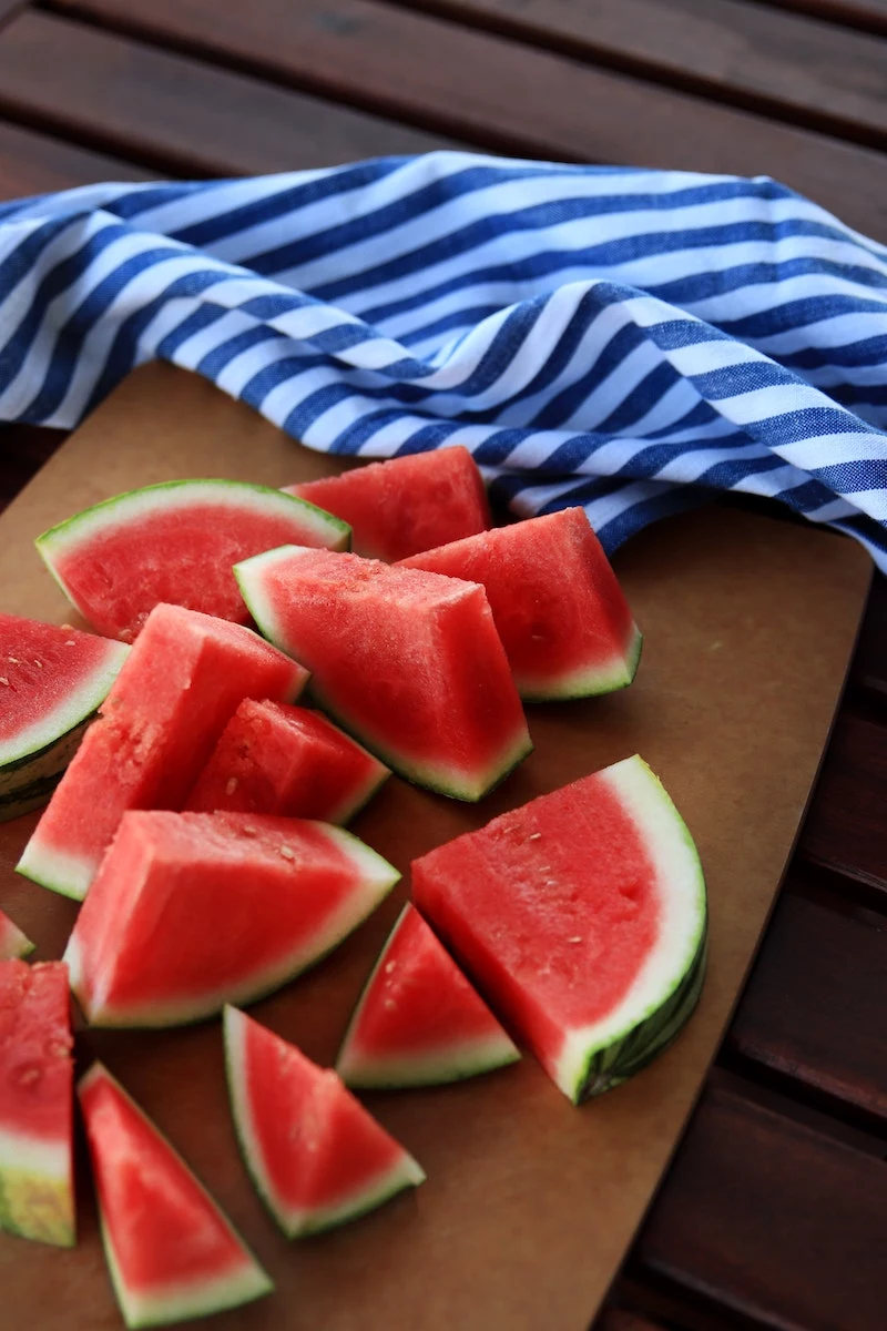 watermelon slices next to blue towel