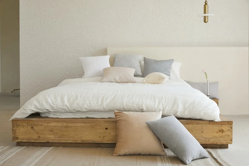 white bed sheets with gray and orange pillows