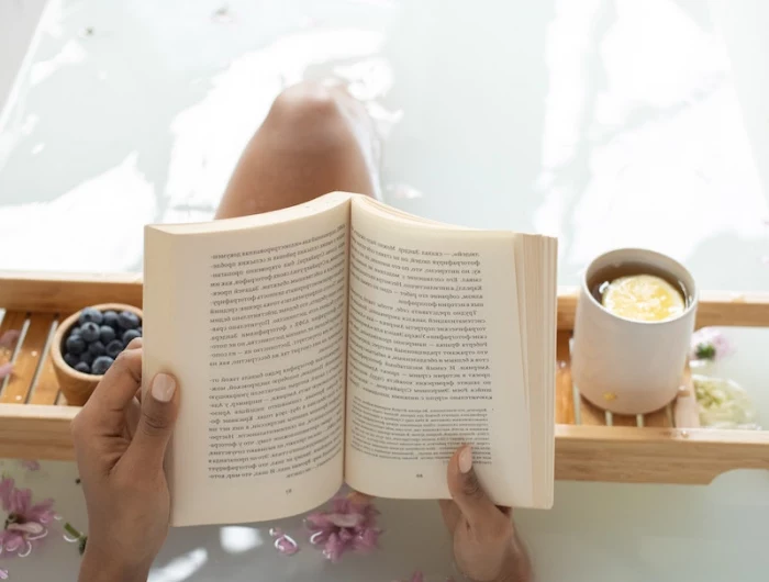 woman in the bath tub reading a book