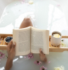 woman in the bath tub reading a book