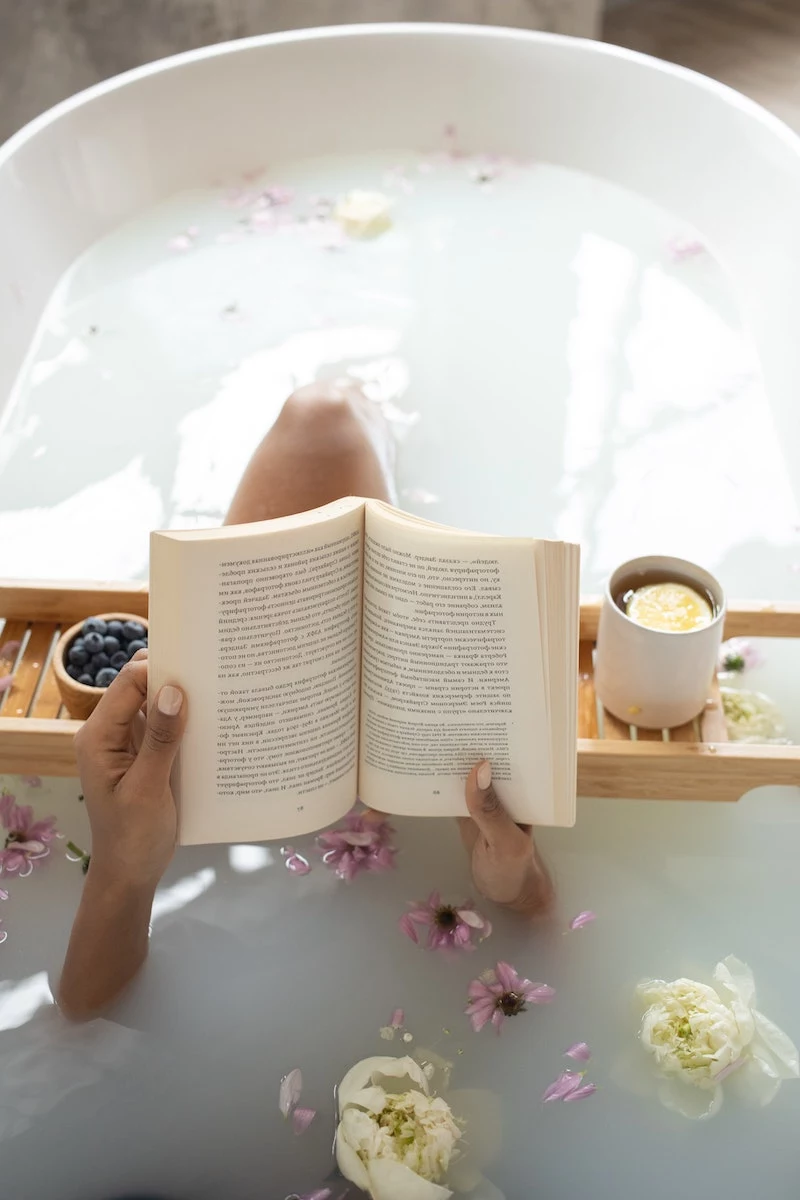 woman in the bath tub reading a book