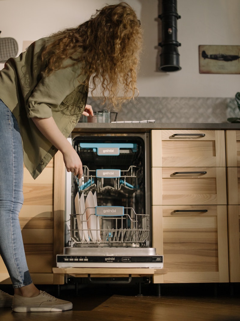 woman standing in front of a dishwasher