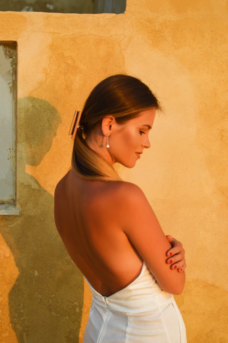 woman with golden tan posing with naked back