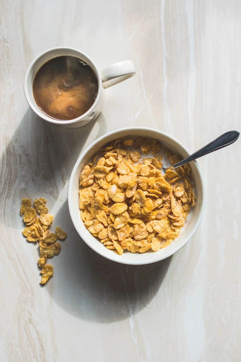 bowl of cereal with cup of coffee on the side