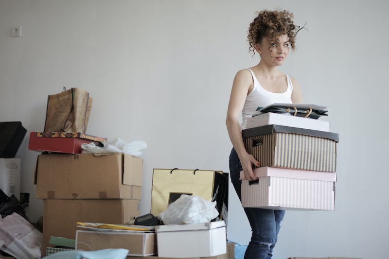 common decluttering mistakes woman holding a box in between clutter