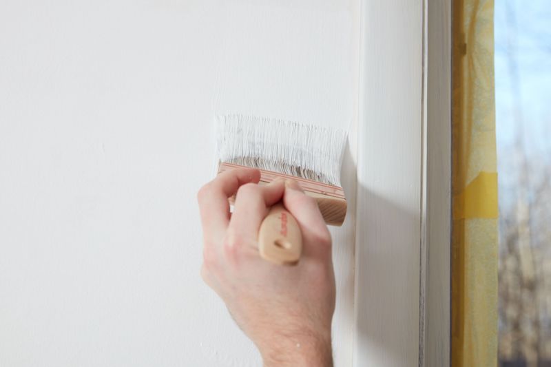 painting mistakes hand painting a wall with white and a brush