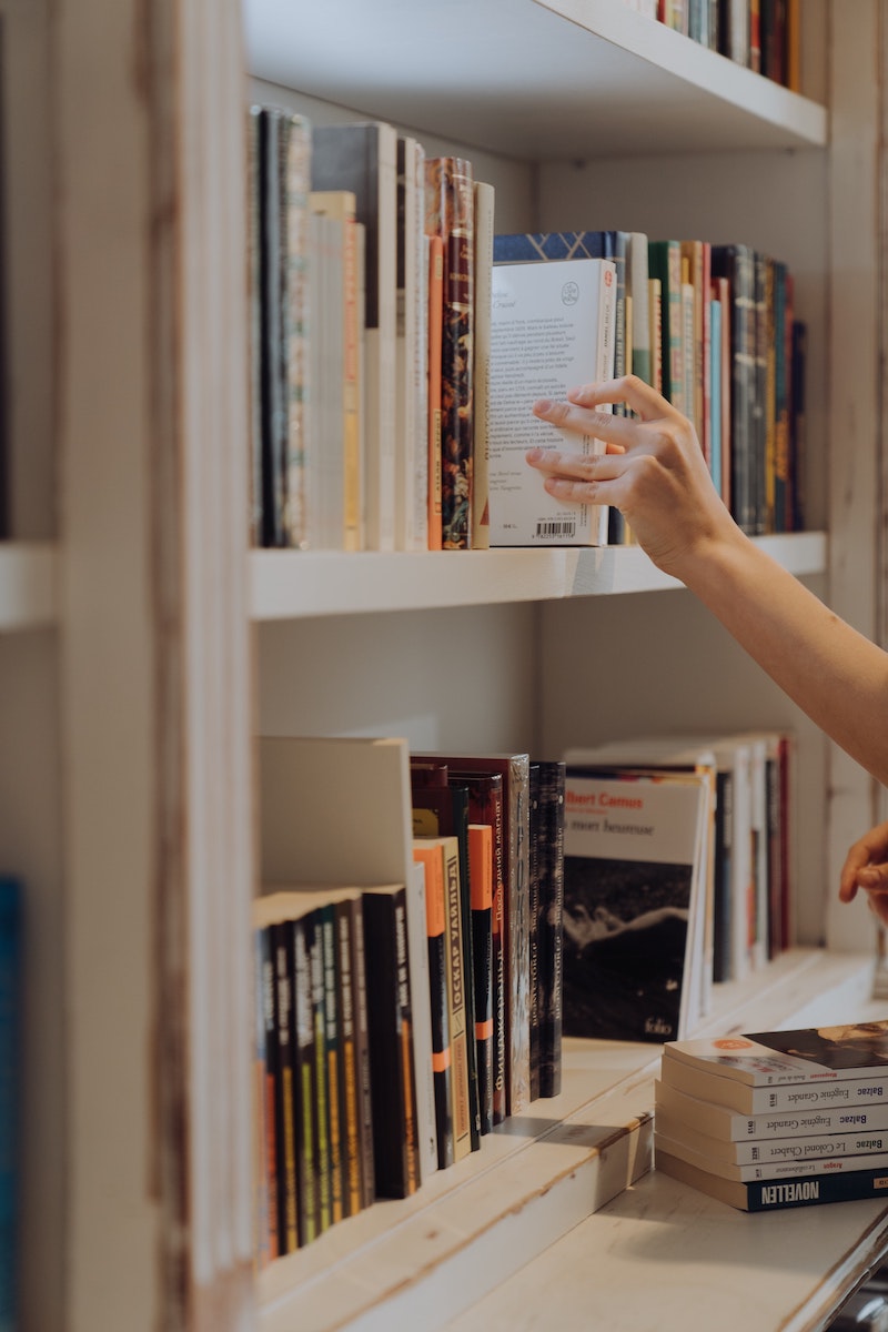 person organizing their book shelf