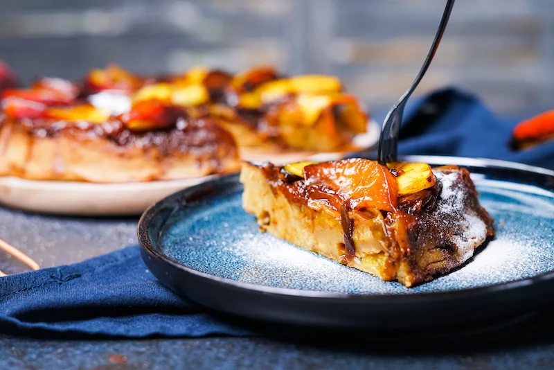 piece of deep dish peach pancake with=fork in t