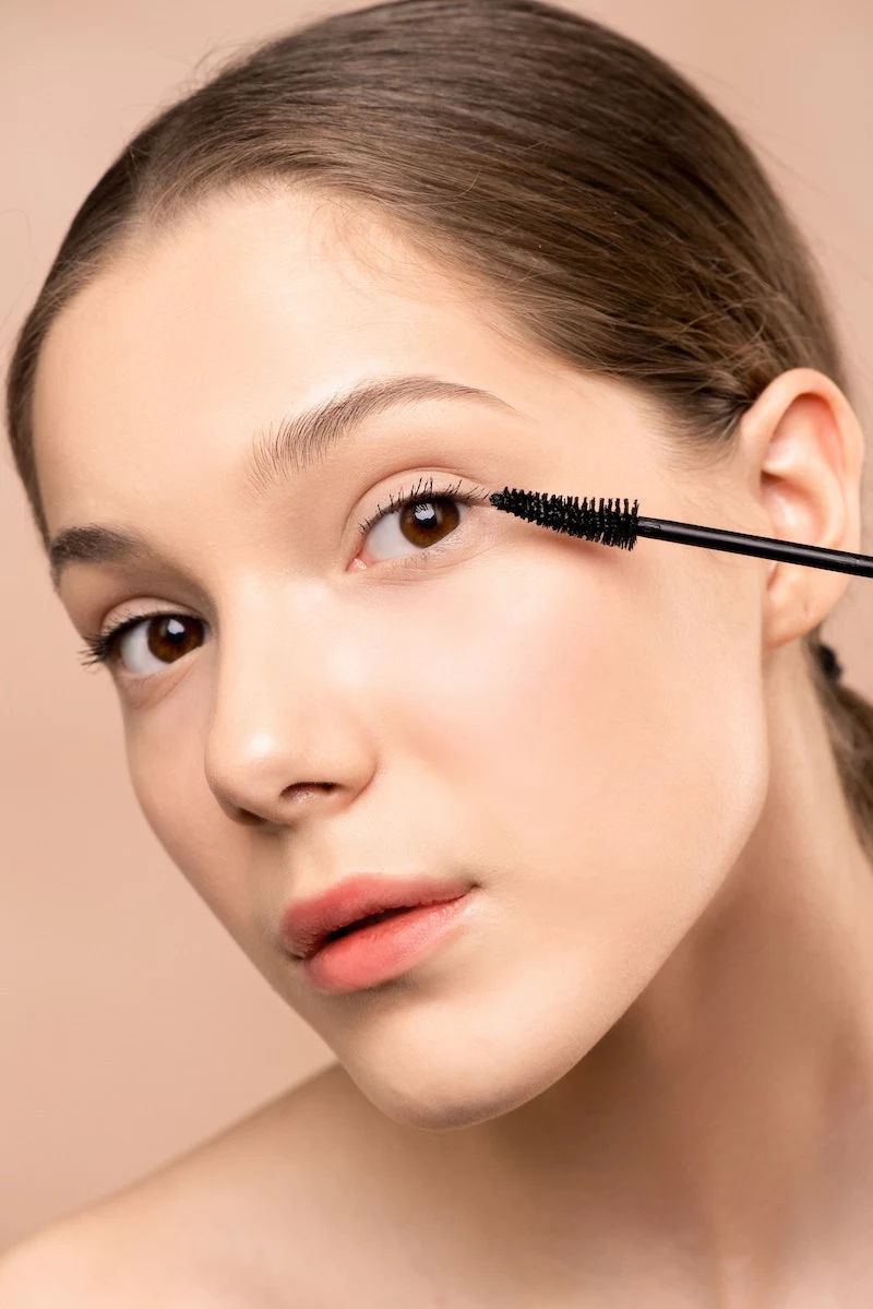 signs your makeup is expired woman applying mascara