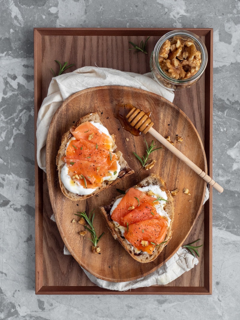 slices of bread with cheese salmon and walnuts on the side