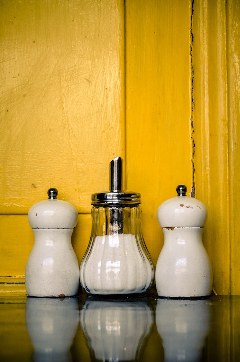 stain removal mistakes white salt and pepper shakers on yellow background
