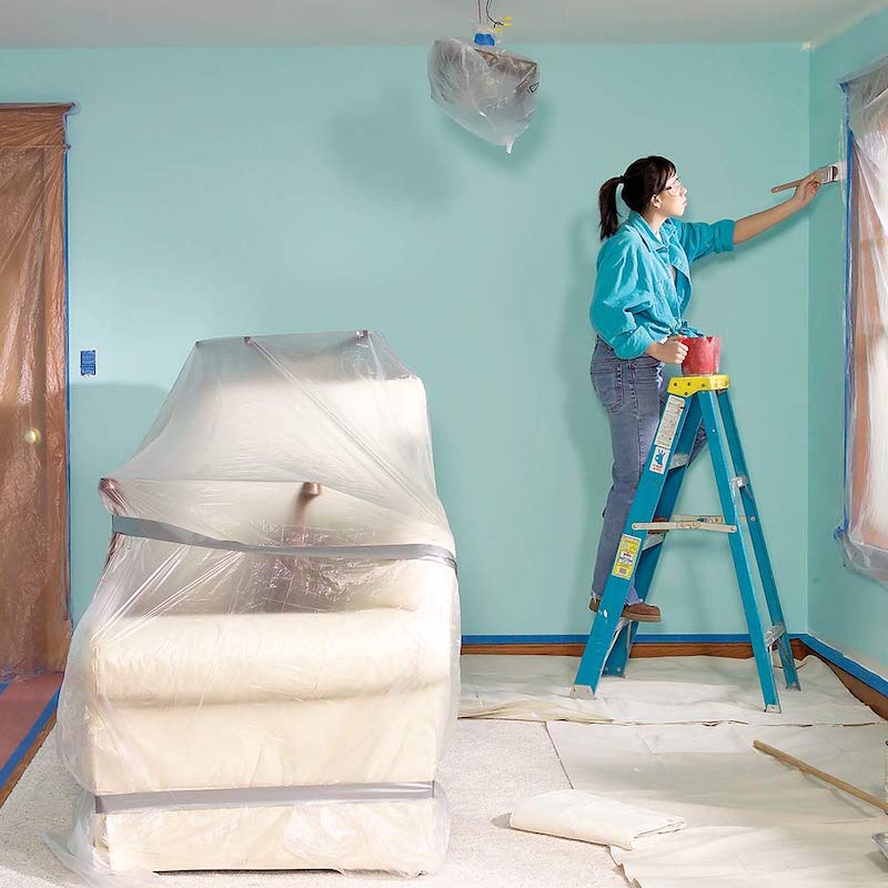 woman painting her room while covered