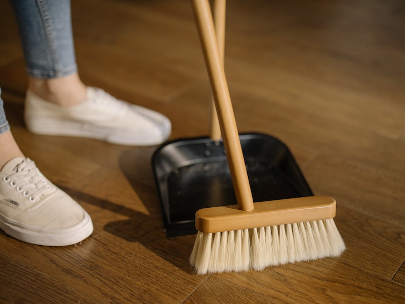 woman sweeping with broom and pan