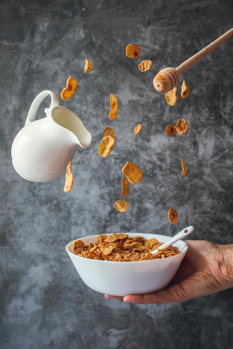 bowl of cornflakes flying into bowl with milk