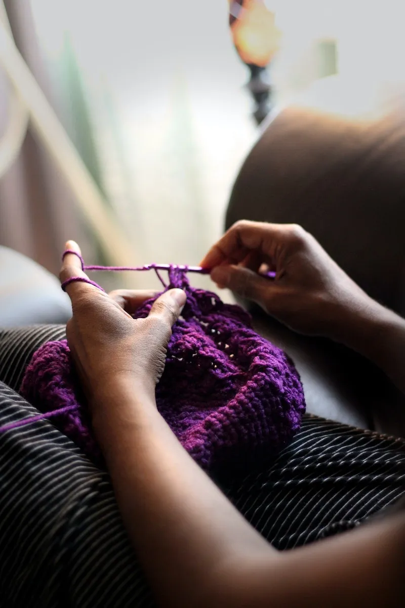 brain exercises woman learning how to crochet with purple yarn