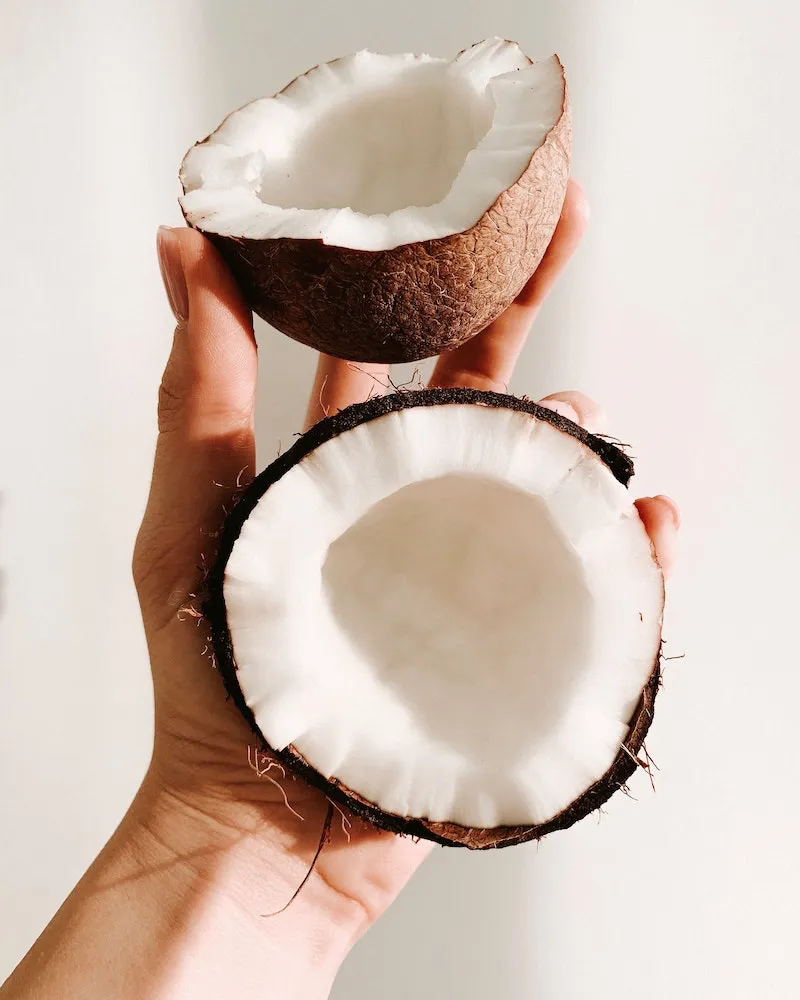 coconut chopped in half held by hand