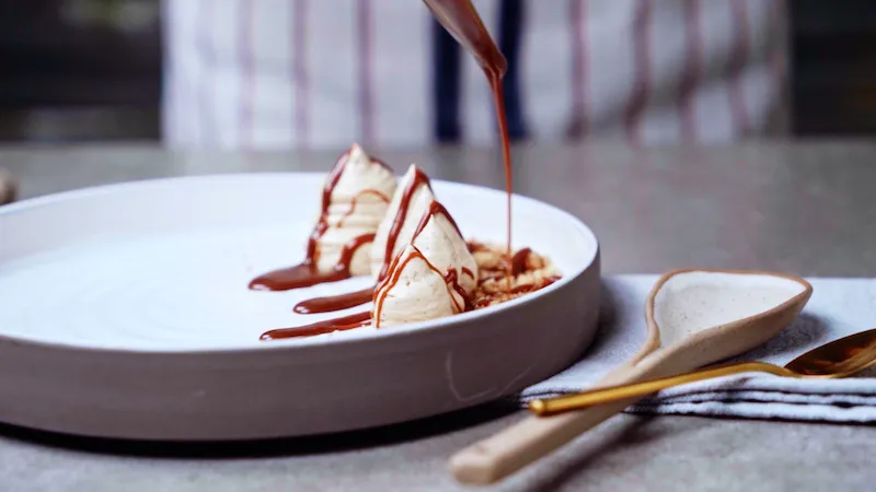 drizzling chocolate on tahini mousse