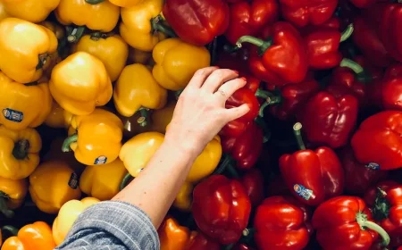 foods you should eat raw hand picking out peppers from store