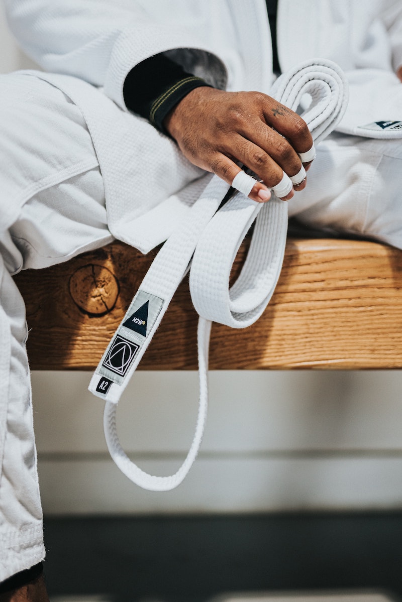 man in martial arts costume holding white belt