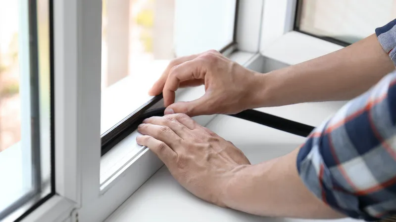 man insulating the window