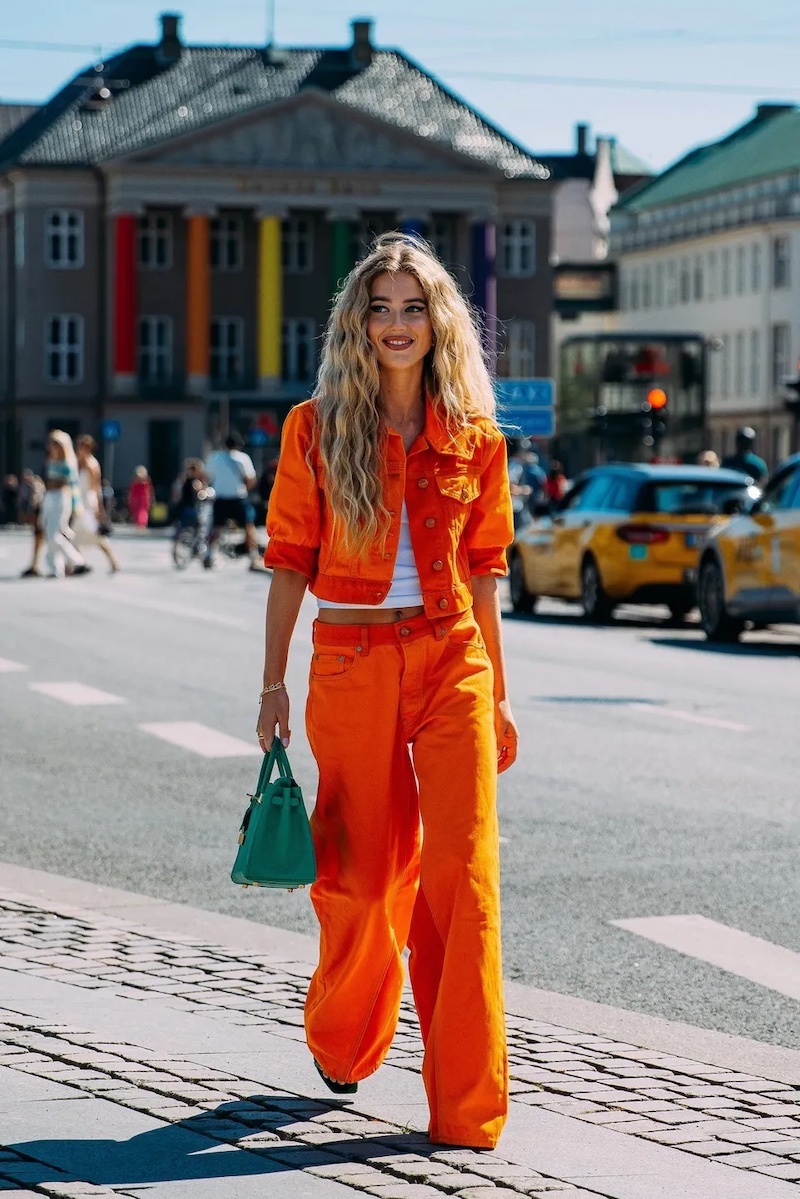 orange jumpsuit with green bag and white top