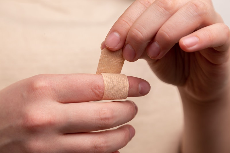 person putting a band aid on finger