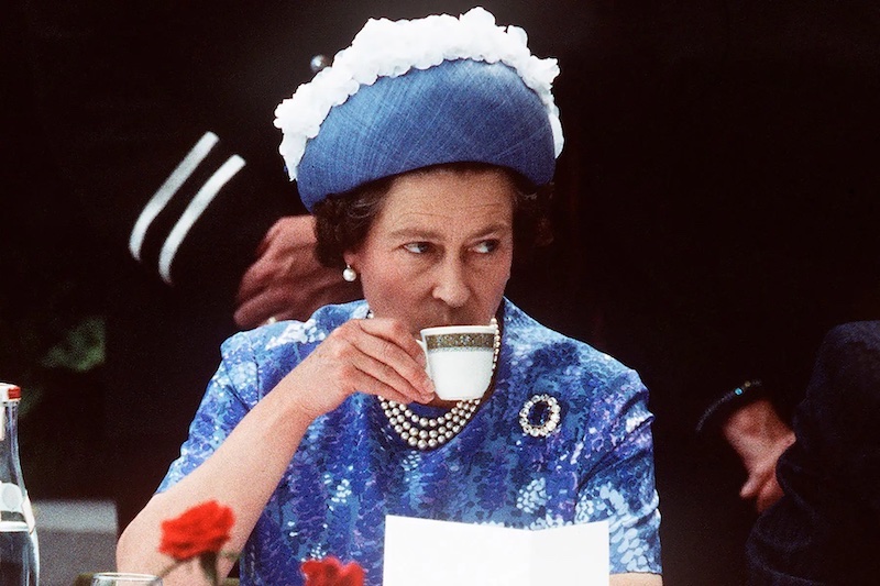 queen elizabeth enjoying tea in blue dress
