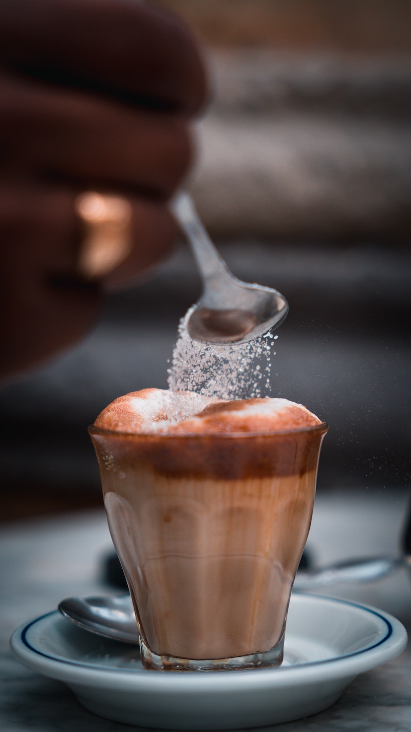 sugar being poured into coffee