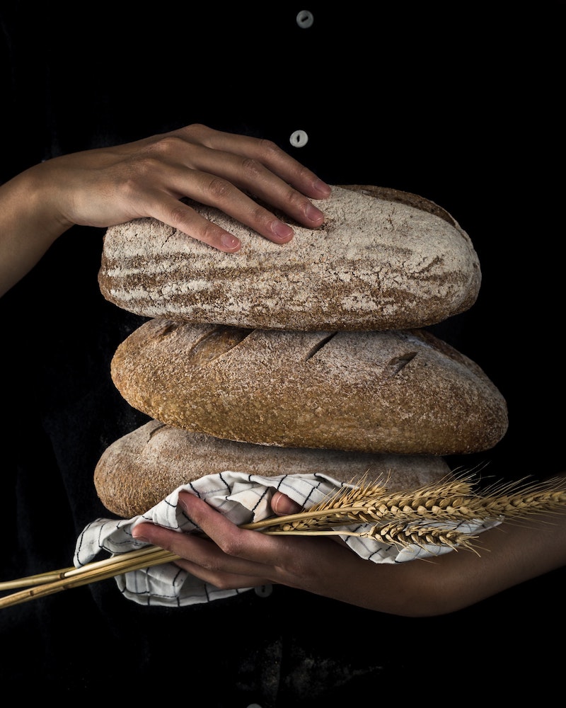 three loafs of bread being held