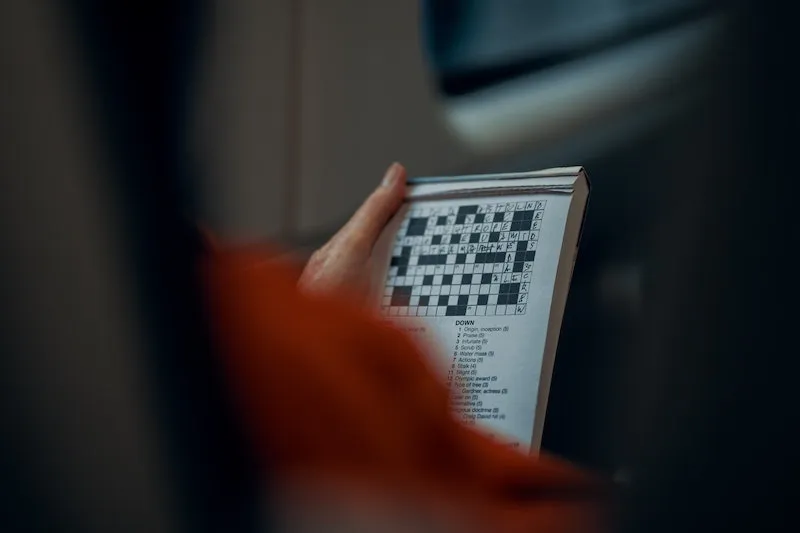 woman holding a book of cross word puzzles