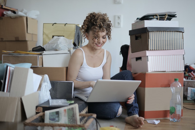 woman sitting on her laptop with boxes around her