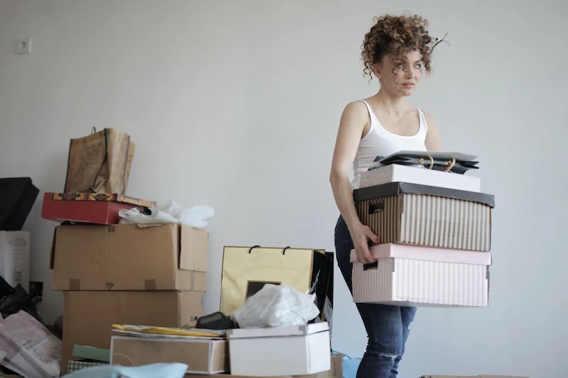 woman surrounded by boxes and things