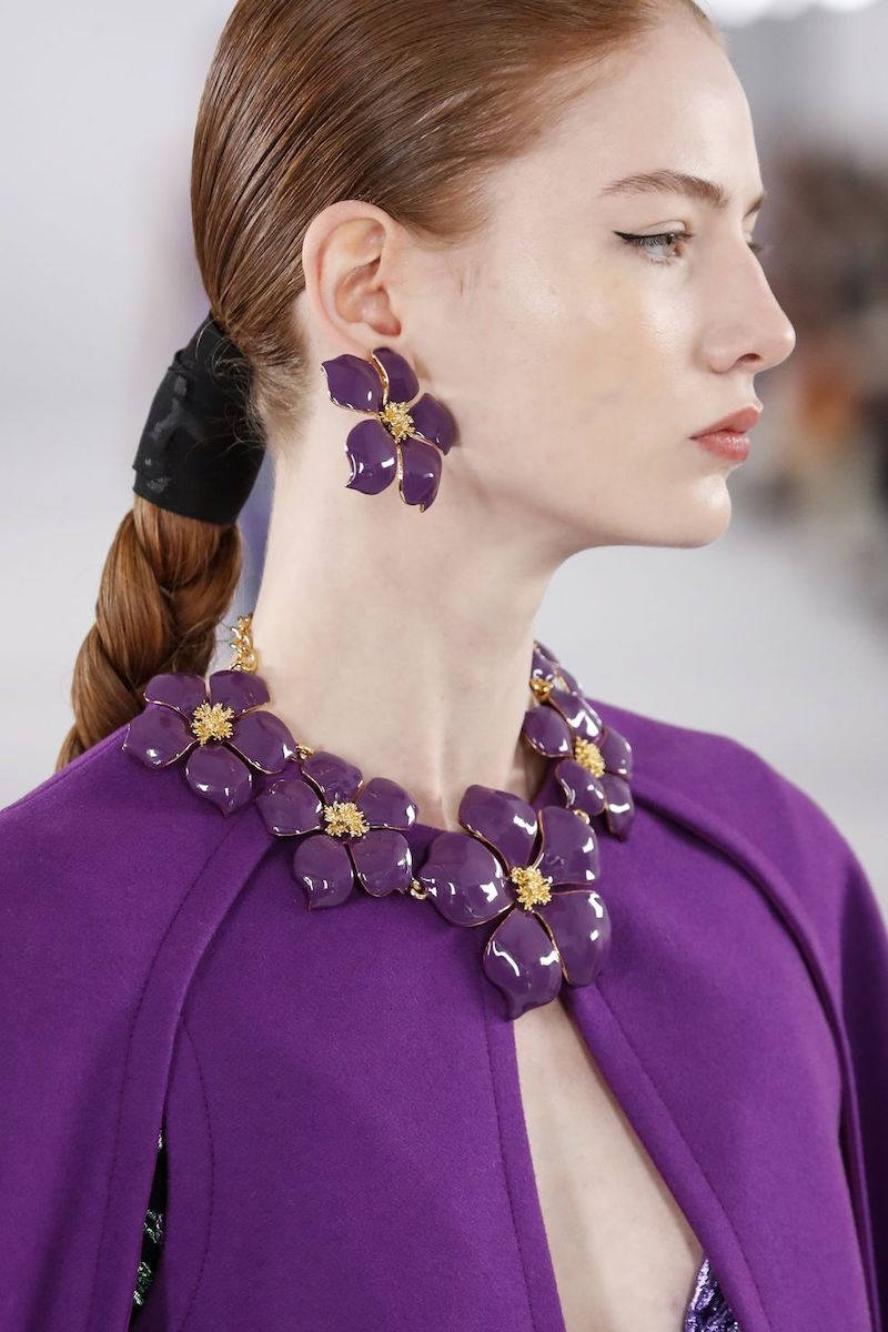 woman with big purple necklace and big purple earings