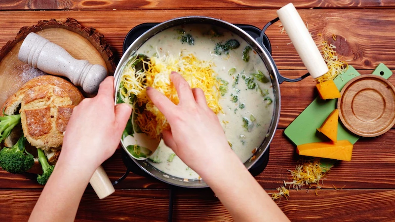 adding grated cheddar to milk soup