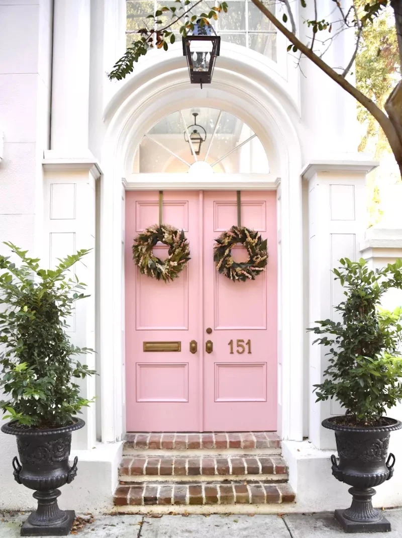 big pink doors with two wreathes on them