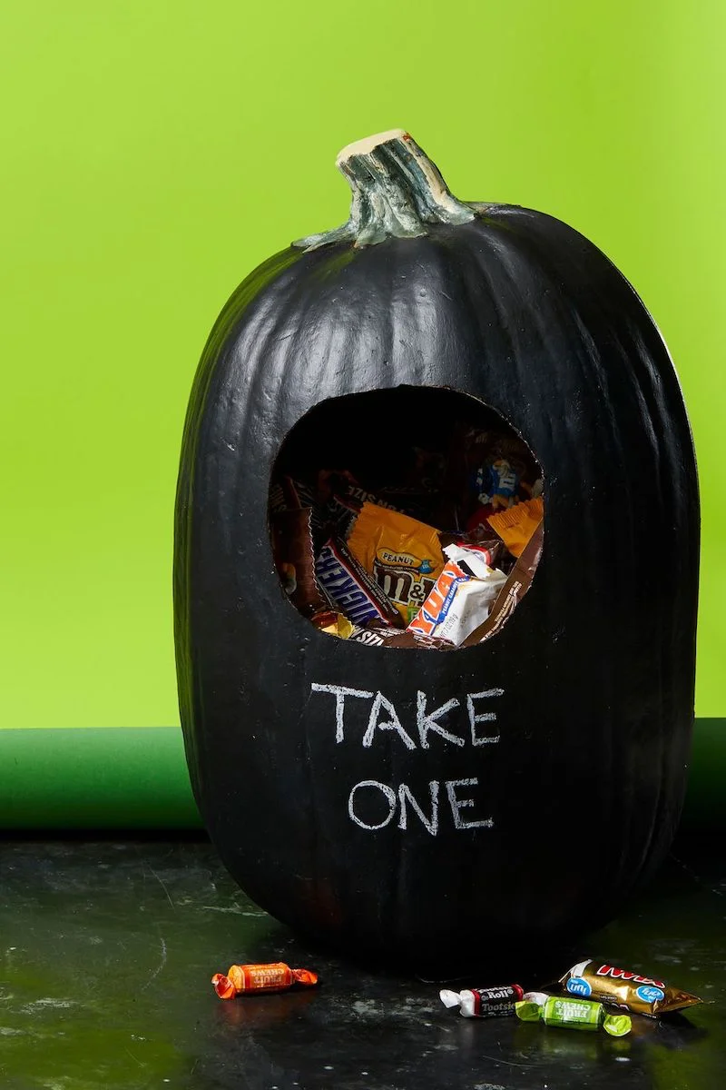 black pumpkin that says take one with candy inside