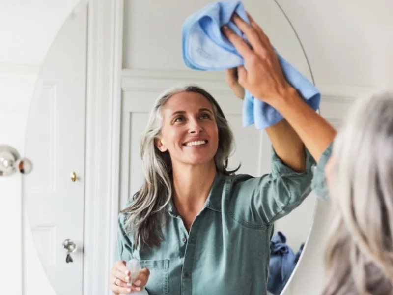 clean mirrors without streaks woman cleaning a mirror