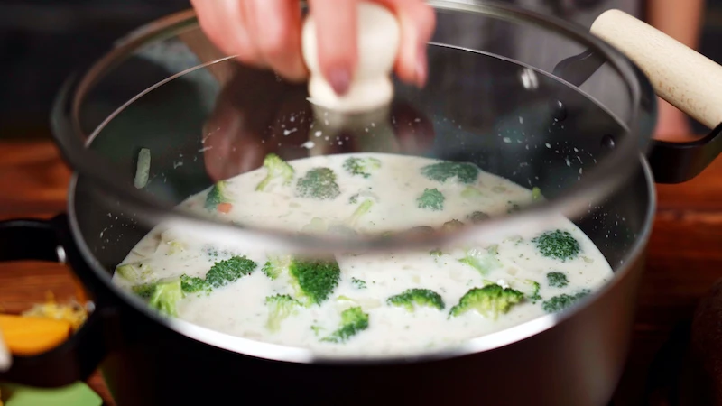 covering a pot of soup with a pan