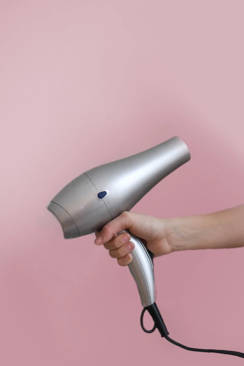 gray hair dryer on a pink background