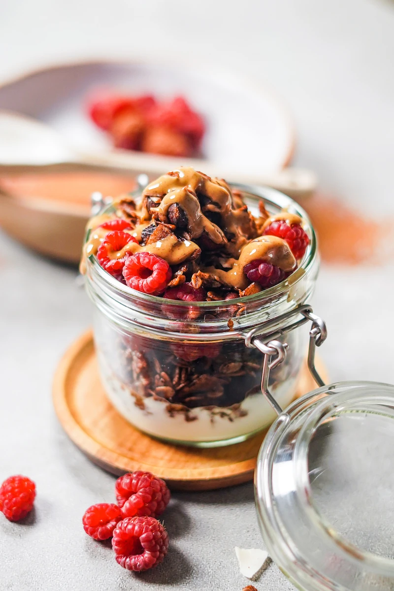 homemade granola with yogurt parfait with raspberries and peanut butter drizzle