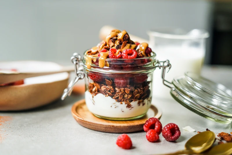 jar with0yogurt granola and raspberries