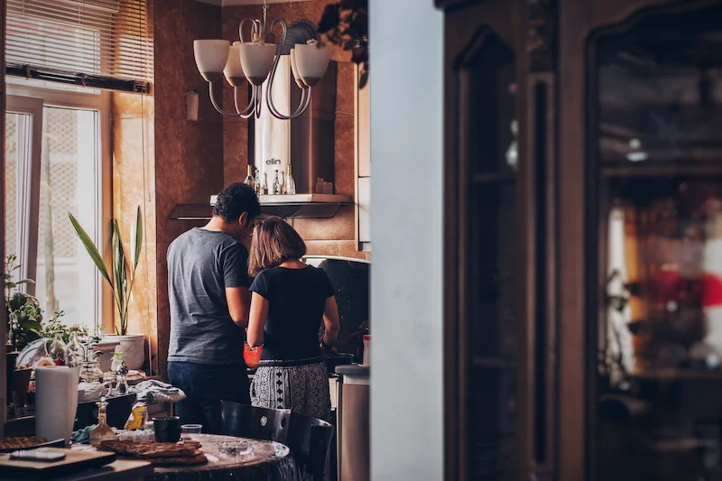 man and woman cooking together in the kitchen